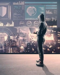 Man standing with a computer in front of an interactive panel